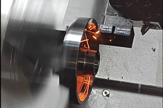 Proces toczenia na tokarce CNC, widoczne iskrzenie oraz obracające się wrzeciono 